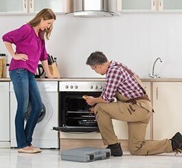 Male Worker Checking The Oven — Appliance Repair in Wauwatosa, WI Male Worker Checking The Oven — Appliance Repair in Wauwatosa, WI