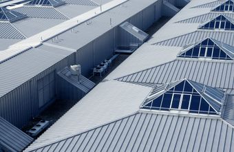 Metal roof with triangular skylights. Industrial building with angled rooflines.