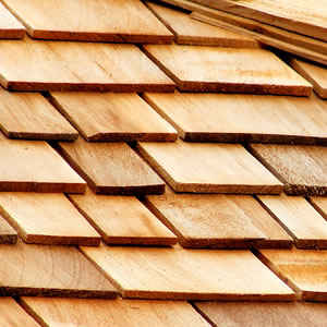 Close-up of overlapping, light brown wooden shingles on a roof.