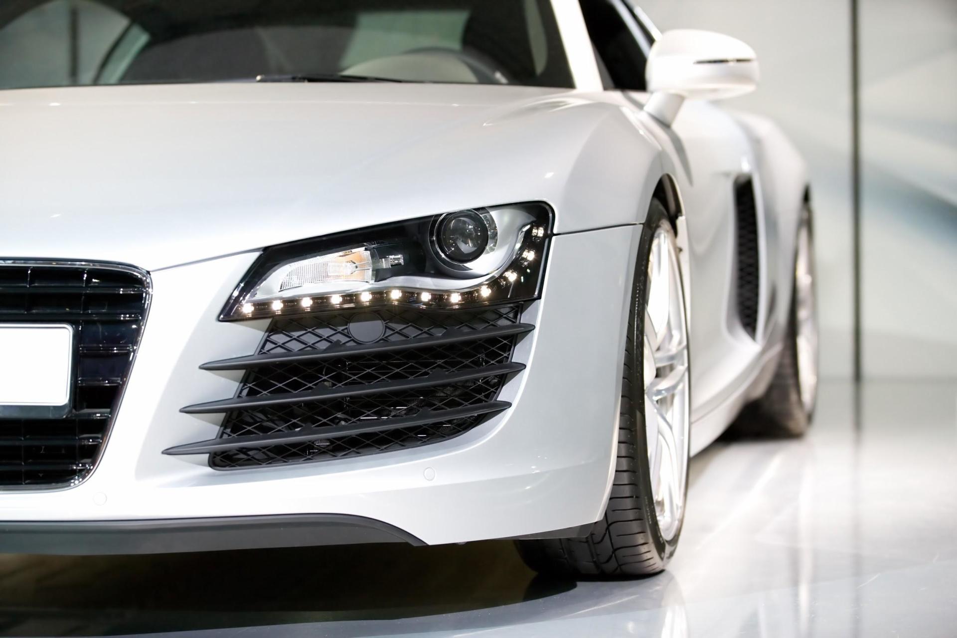A silver sports car is parked in a showroom