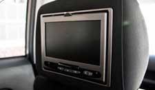 A headrest mounted dvd player in a car.