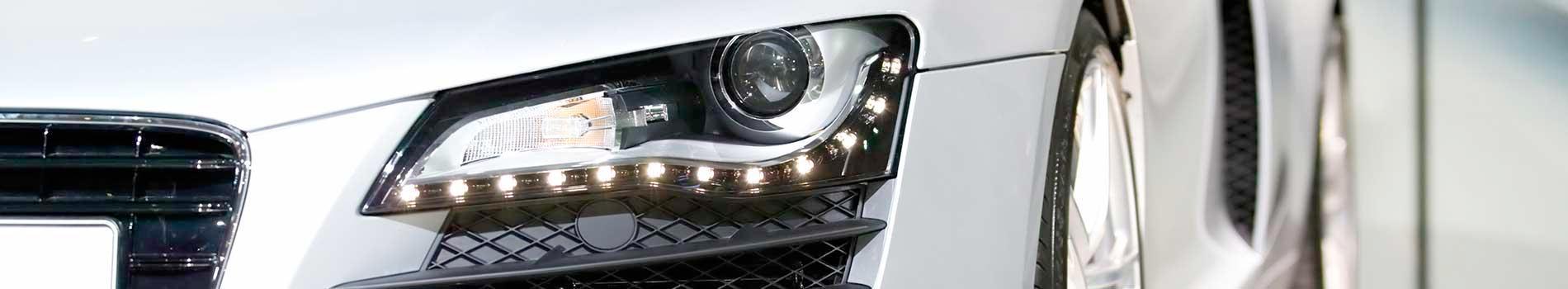 A close up of a car 's headlight on a white background.