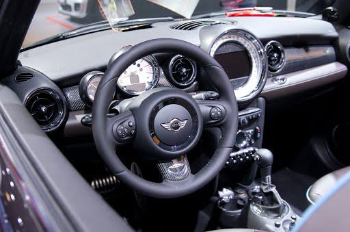 The interior of a mini cooper with a steering wheel