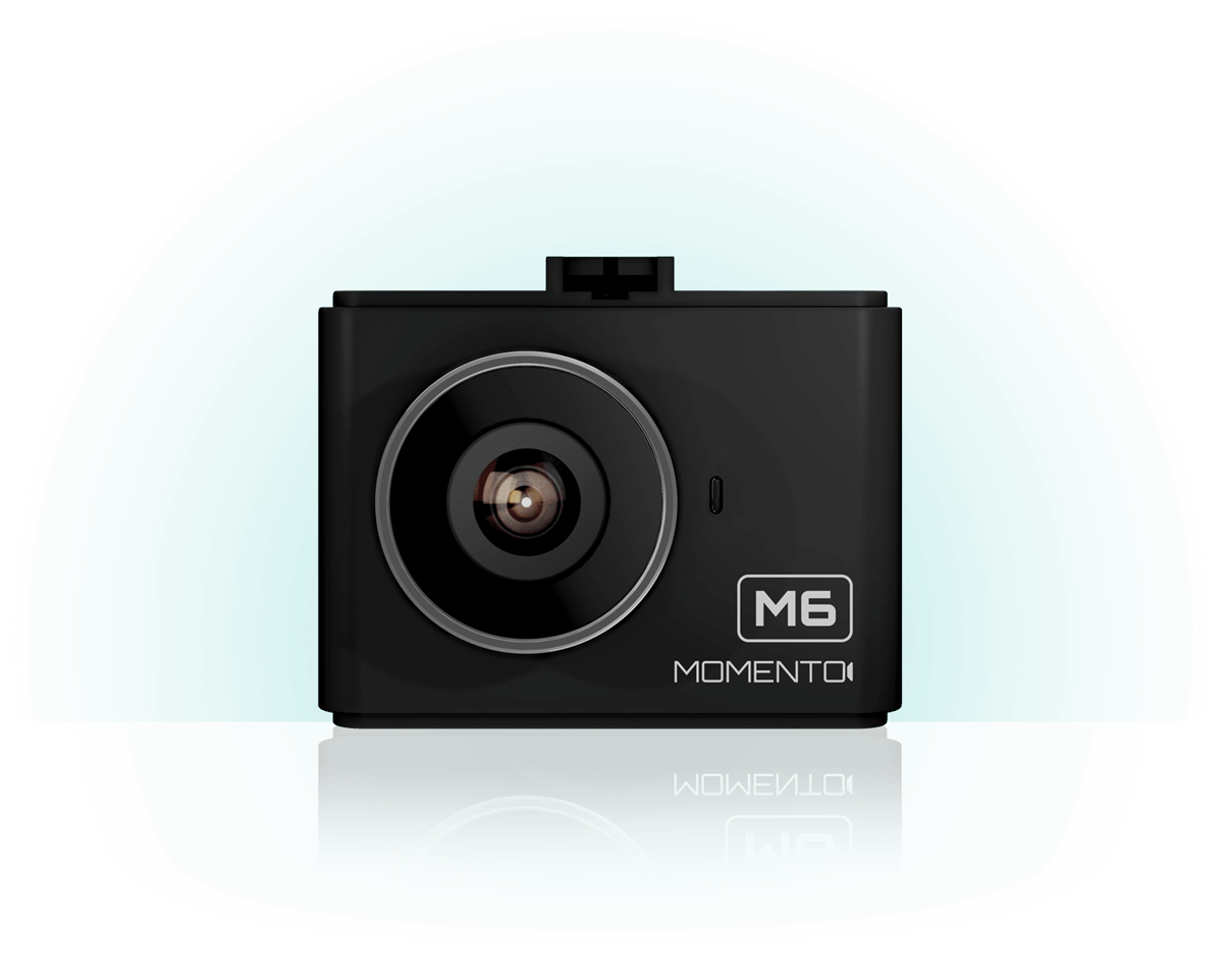 A black camera is sitting on a white surface.