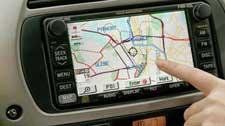 A person is pointing at a map on a car radio.