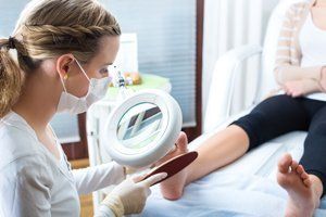 A female therapist using a foot file on a patient