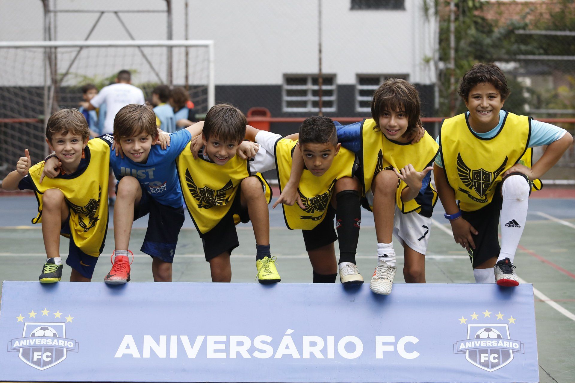 Grupo de crianças com coletes amarelos posa para foto no evento 