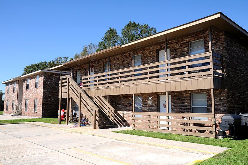 A brick apartment building with stairs leading up to the second floor