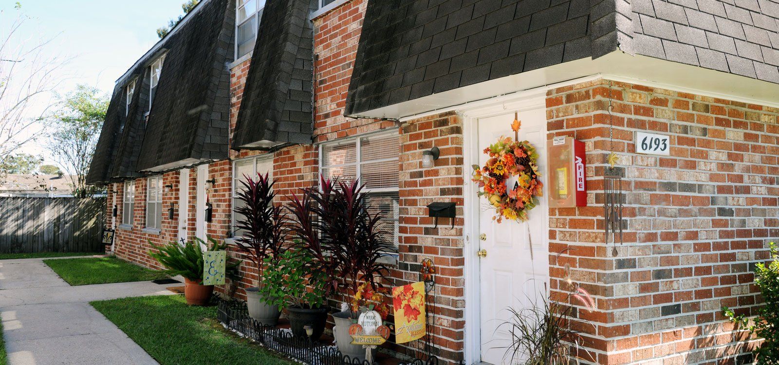 A brick apartment building with a wreath on the door.