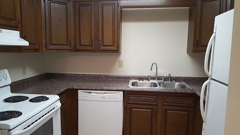 A kitchen with a stove a sink and a refrigerator