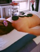 A woman with a flower in her hair is getting a massage