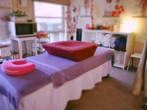 A massage table with a red bowl on top of it