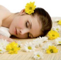 A woman is laying on the floor with flowers in her hair.