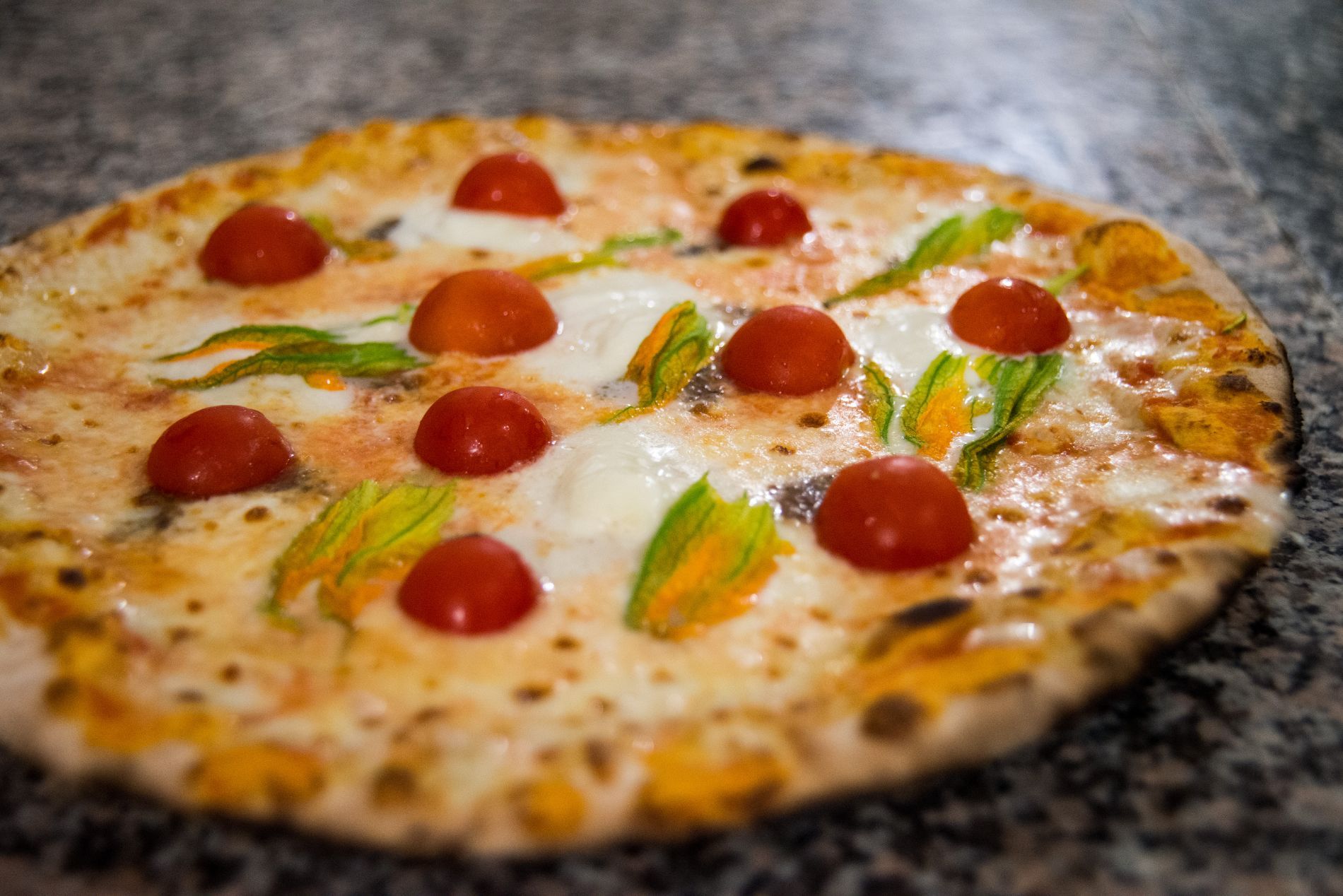 pizza with cherry tomatoes cooked in a wood-fired oven