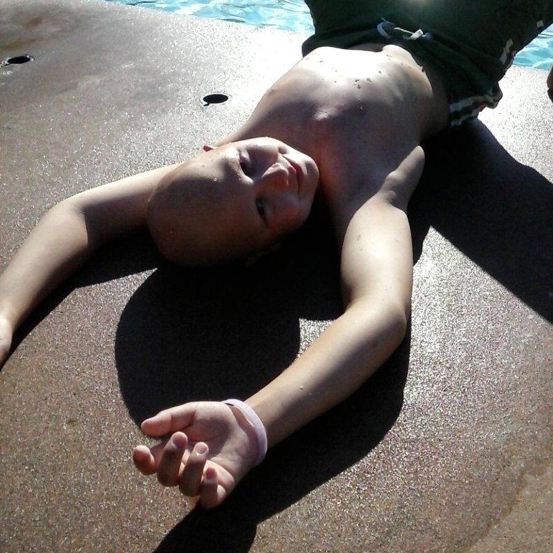 Samuel, boy laying at the pool.
