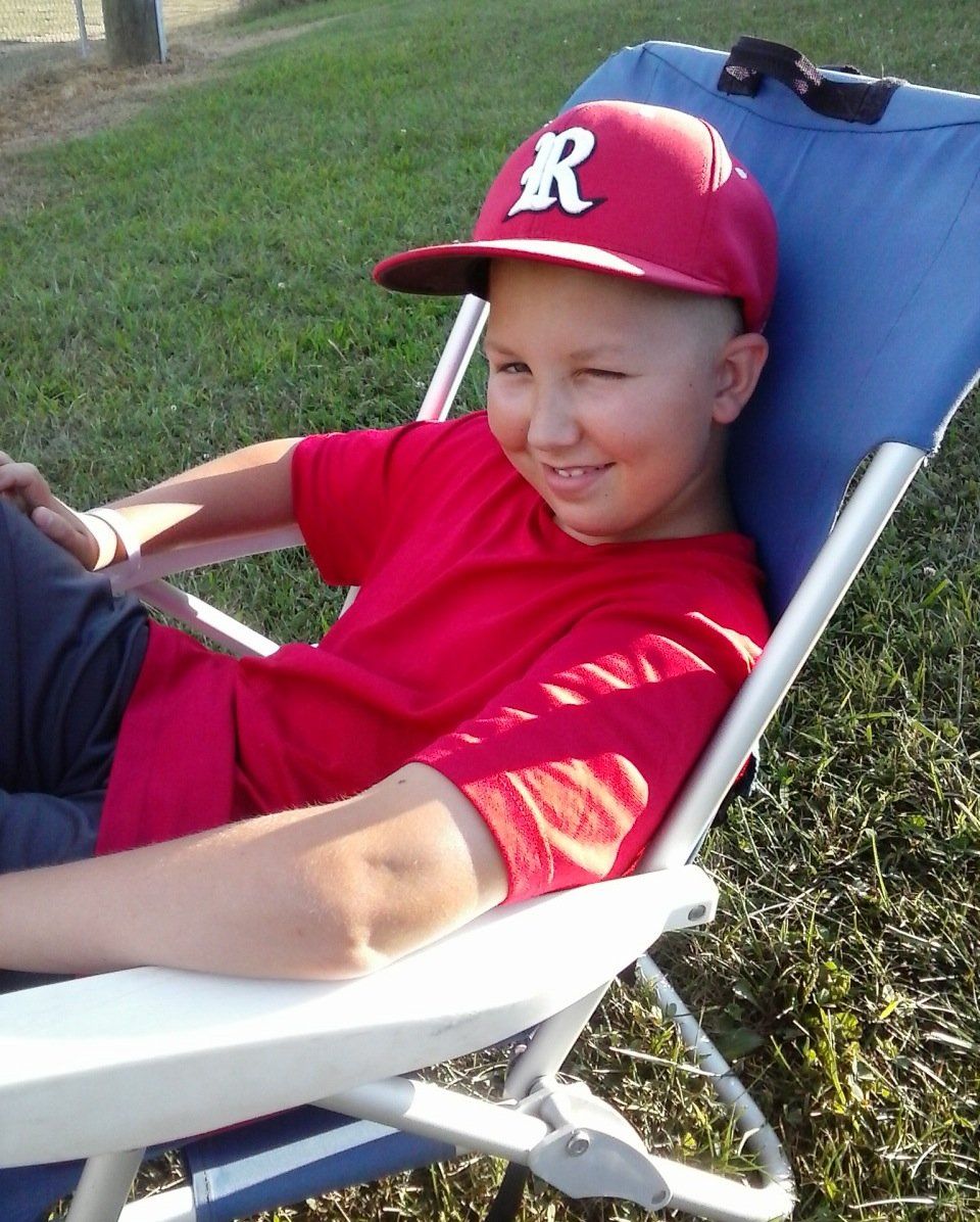 boy winking while sitting in chair.