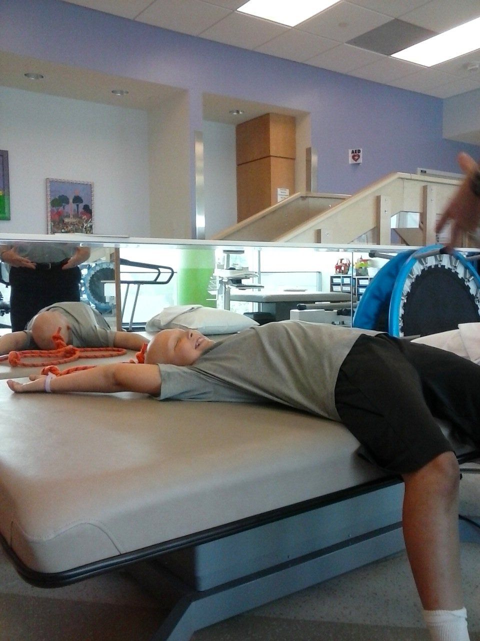 boy laying on bed in physical therapy room.