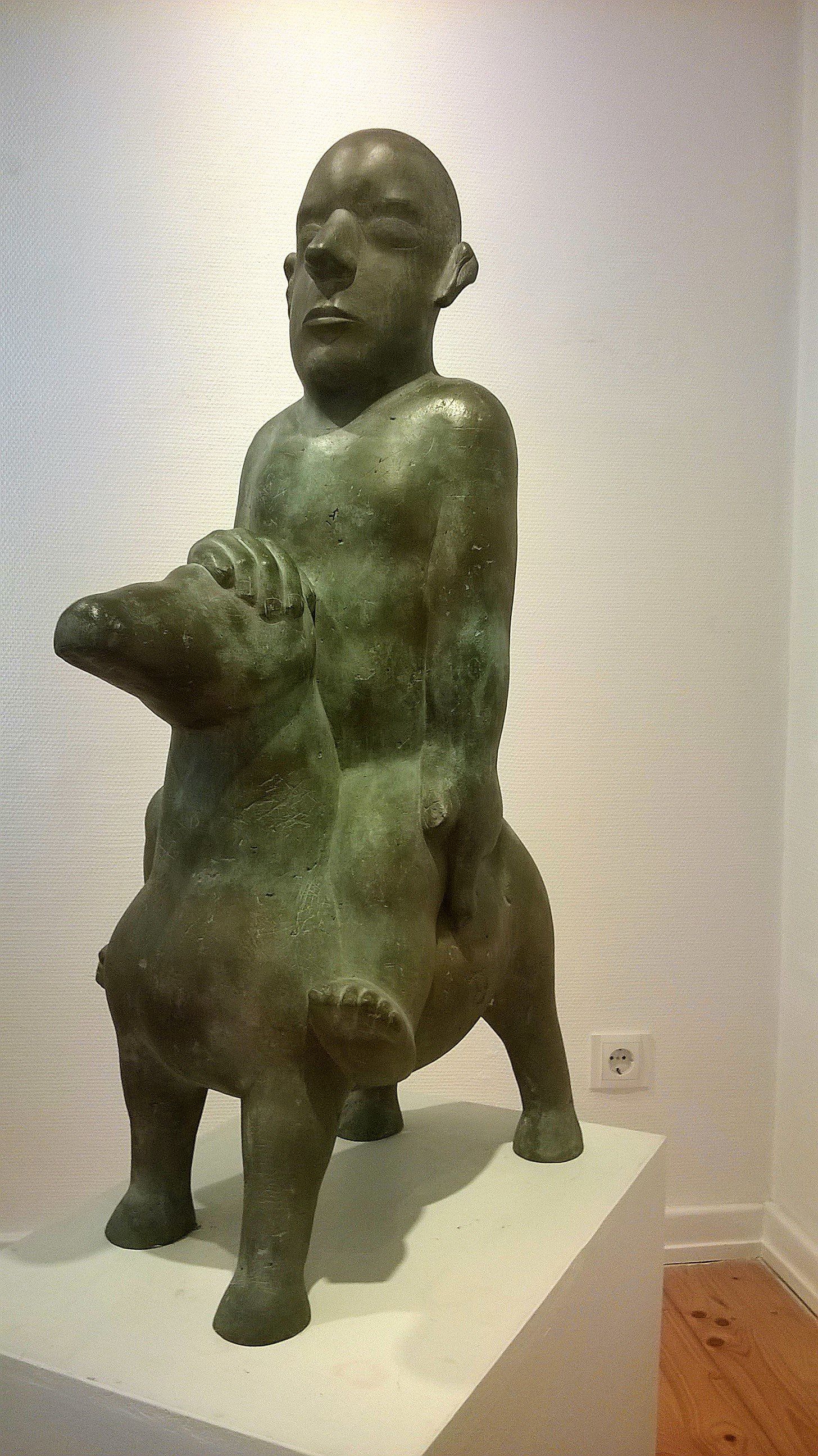Eine Statue eines Mannes, der auf dem Rücken eines Schweins reitet.