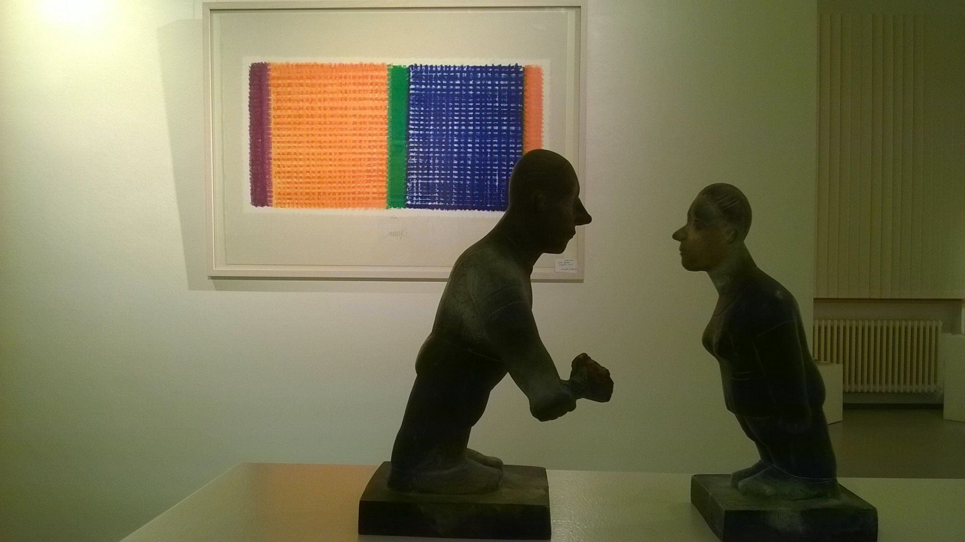 In einem Raum stehen einige Statuen auf einem Tisch.