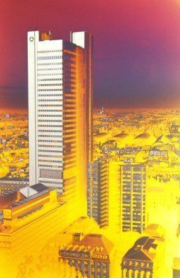 Eine Luftaufnahme einer Stadt mit einem hohen Gebäude im Vordergrund
