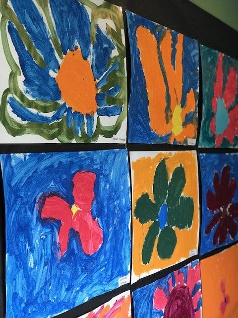 A bunch of colorful paintings of flowers on a wall
