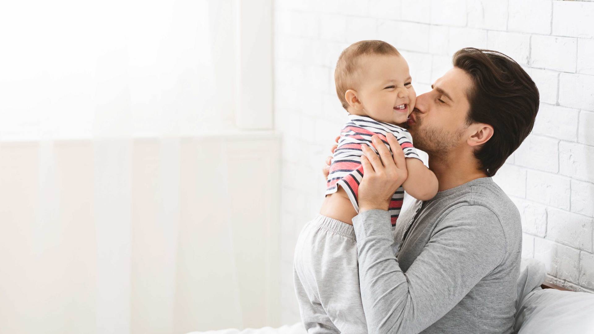 Young Man Kissing His Adorable Baby Son — Huntsville, AL — Elissa Green Attorney at Law