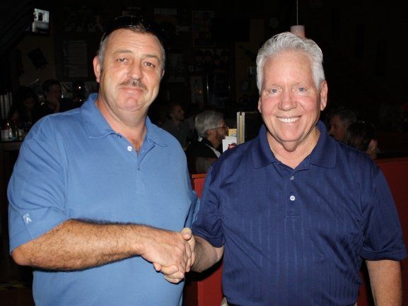 Two men shaking hands in a dark room