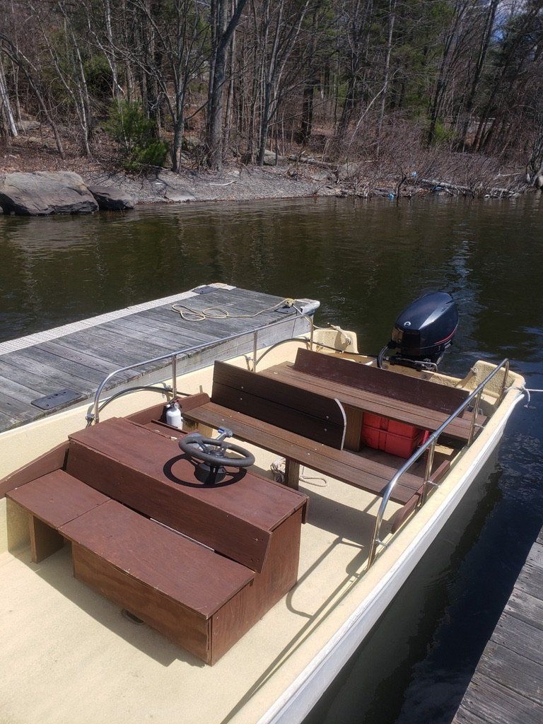 A boat is docked at a dock next to a body of water.