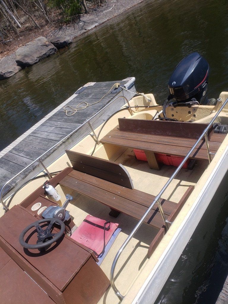 A boat is docked at a dock next to a body of water.