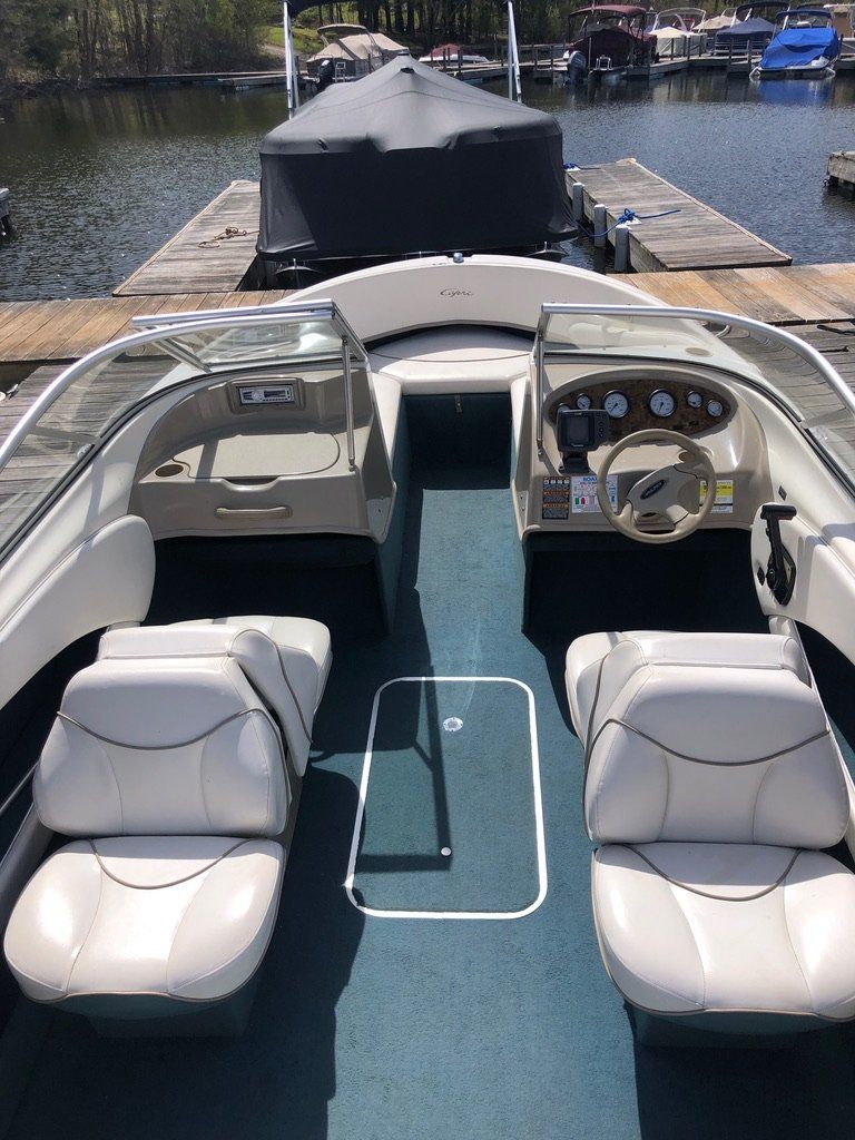 A boat is docked at a dock next to a body of water.