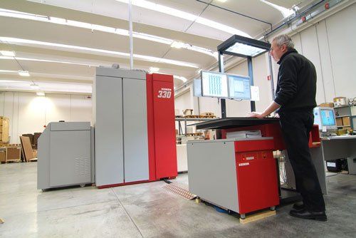 un uomo al lavoro con davanti dei monitor in una fabbrica