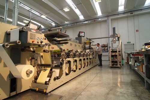 un macchinario per le etichette e un uomo al lavoro
