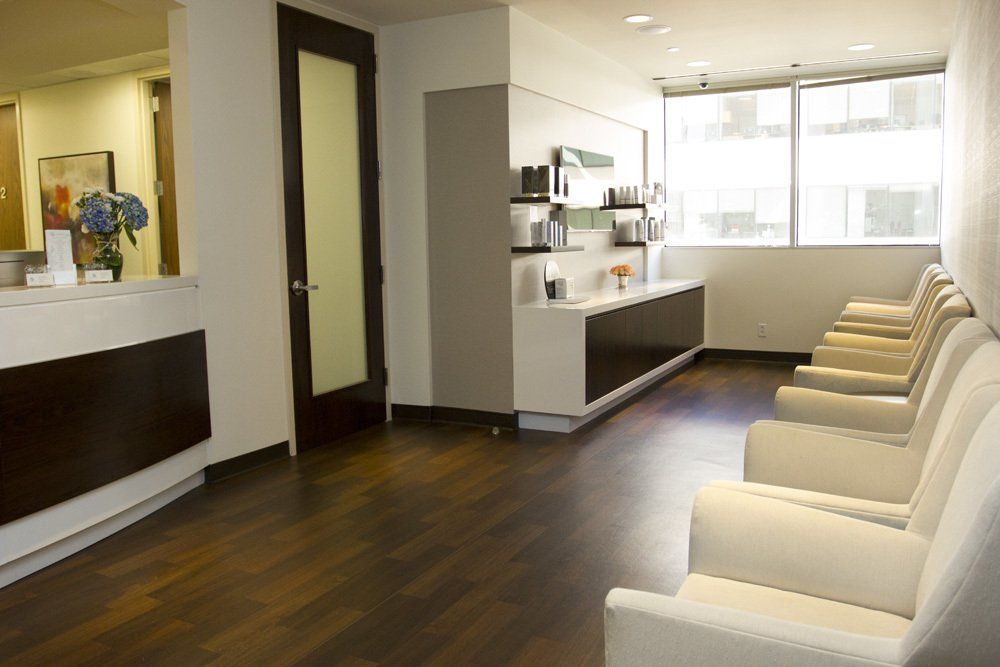 A waiting room with a row of chairs and a counter