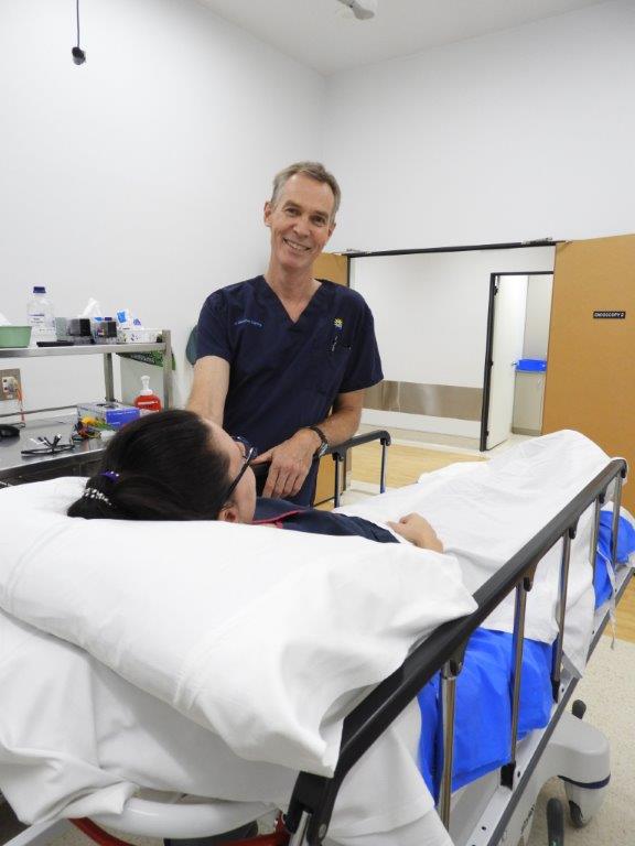 Doctor smiling, standing next to his patient