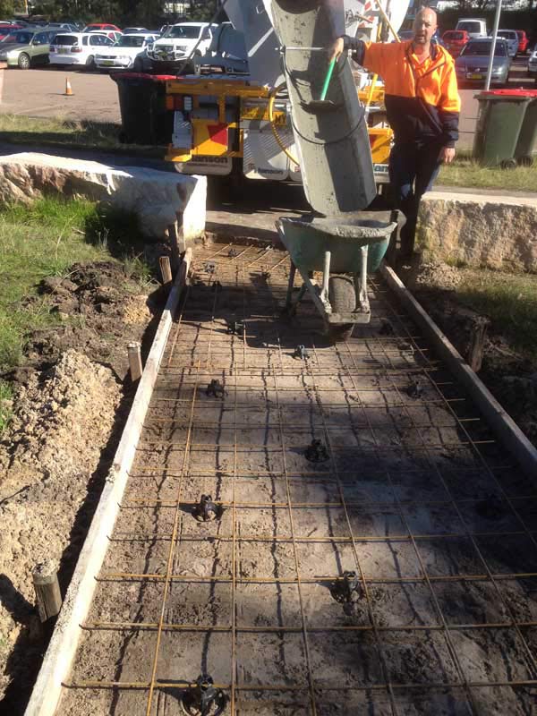 worker standing by concrete wheelbarrow