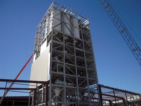 A tall industrial structure with a steel frame against a blue sky.