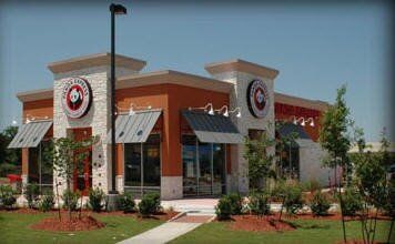 Panda Express restaurant with orange, stone, and gray facade under a blue sky.