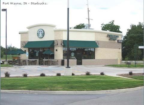 Starbucks in Fort Wayne, IN, with green awnings, outdoor seating, and a drive-thru.