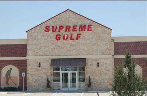 Supreme Golf store exterior with red lettering, tan stone facade, and a golfer silhouette.
