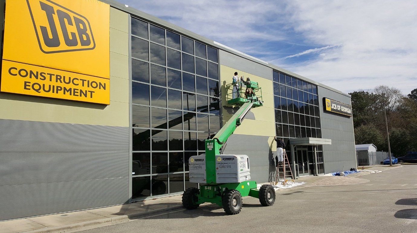 Worker Painting The JCB Building — Pooler, GA — Holcombe Painting & Wallcovering