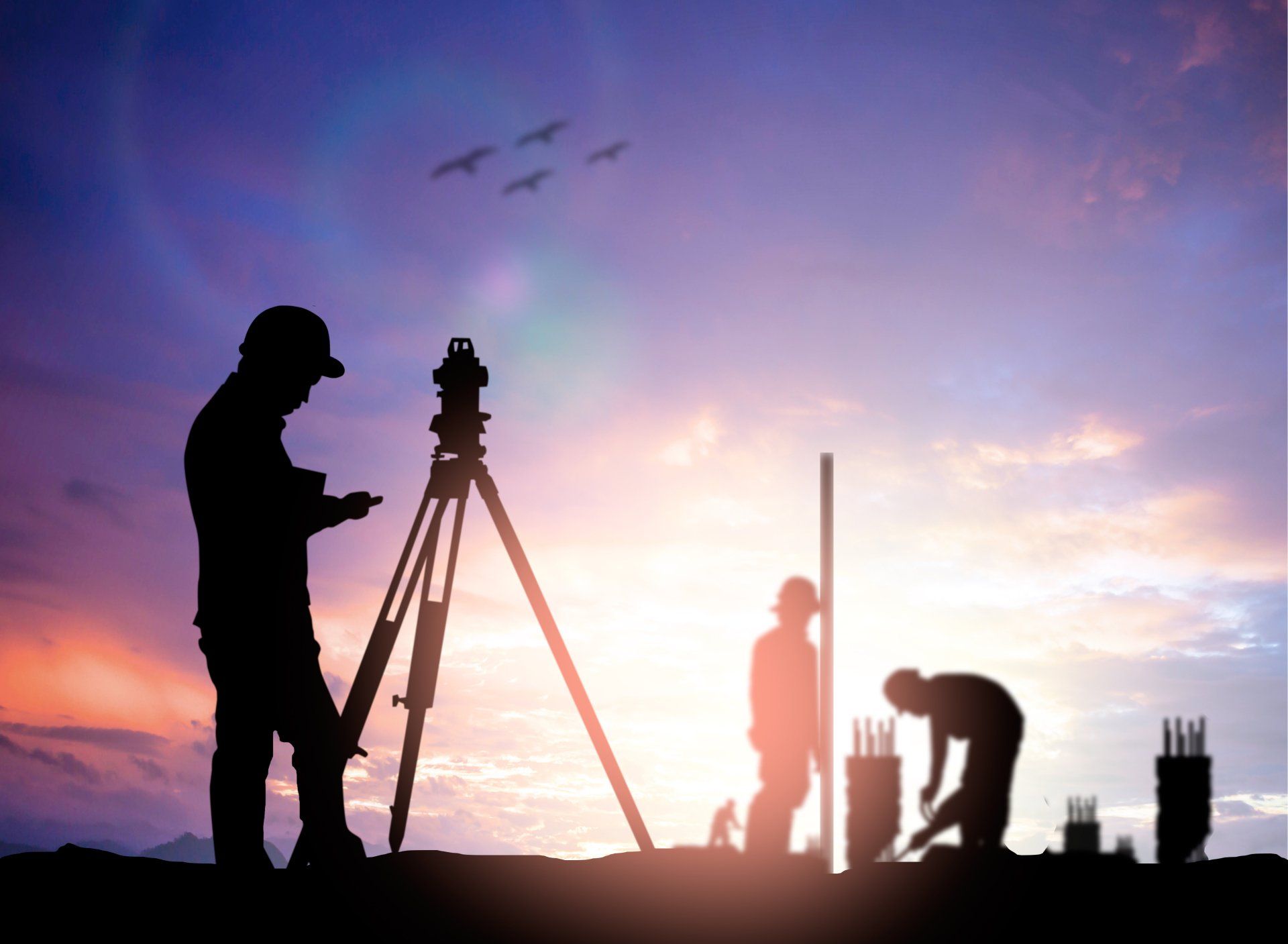 silhouette black man survey civil engineer stand on ground working in a land building site over Blurred construction worker on industrial site.