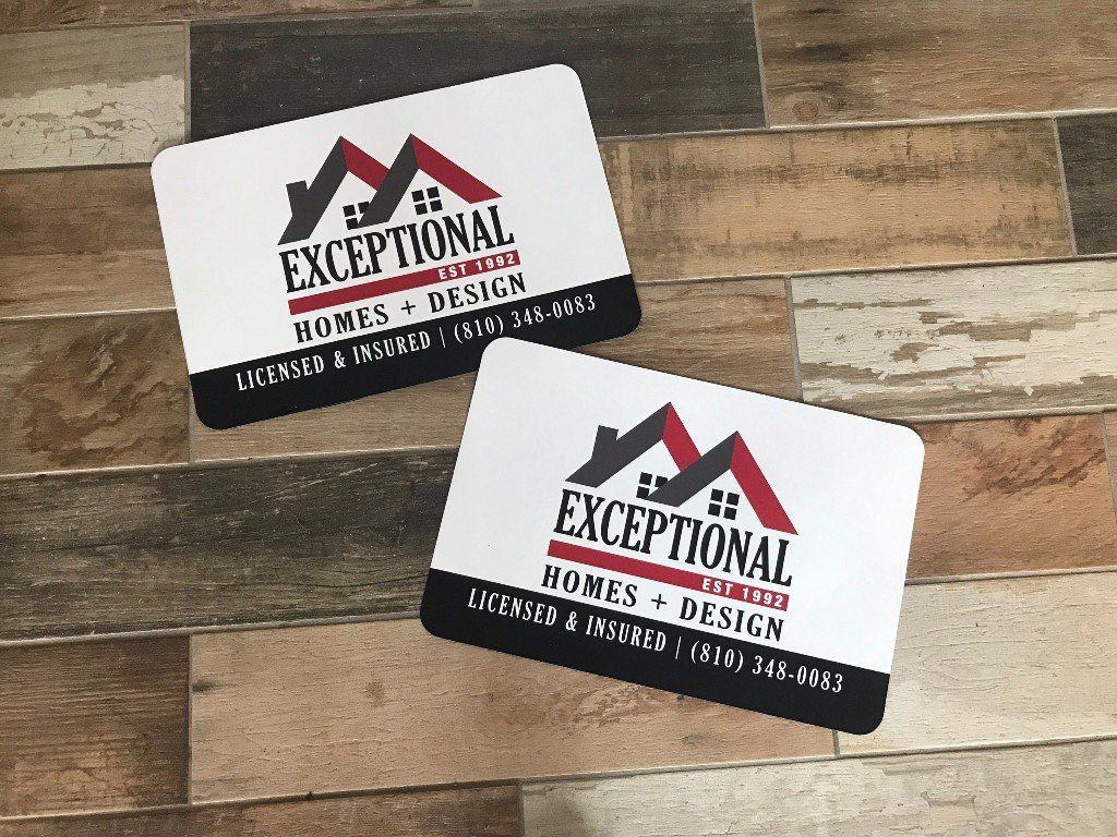 Two black-and-white business cards with red accents on a wooden surface