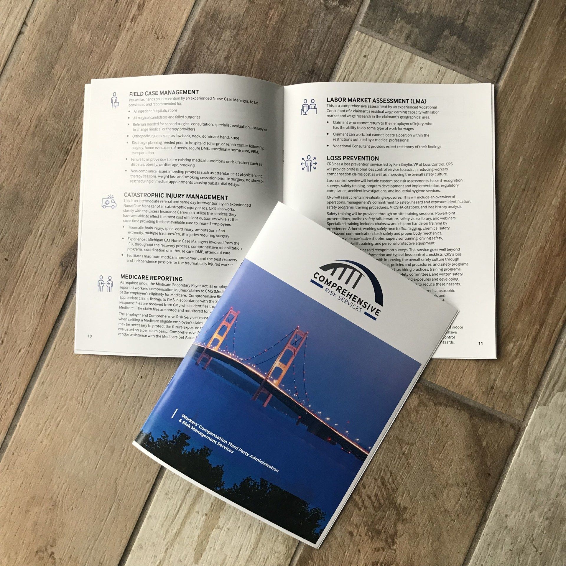 Open book with text and a blue Golden Gate Bridge booklet on a wooden surface