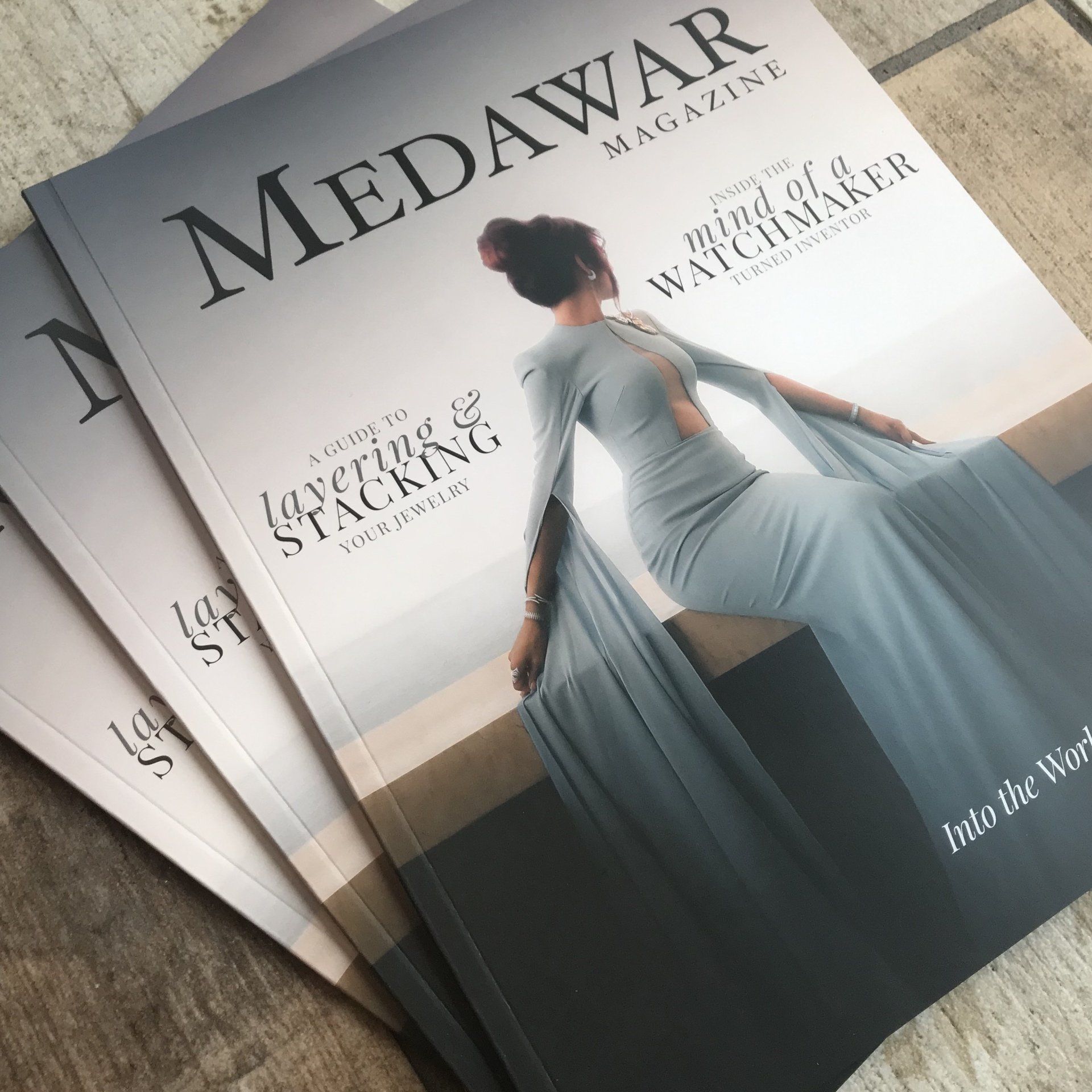 Two Medawar magazines stacked on a table, featuring a woman in a flowing dress on the cover.