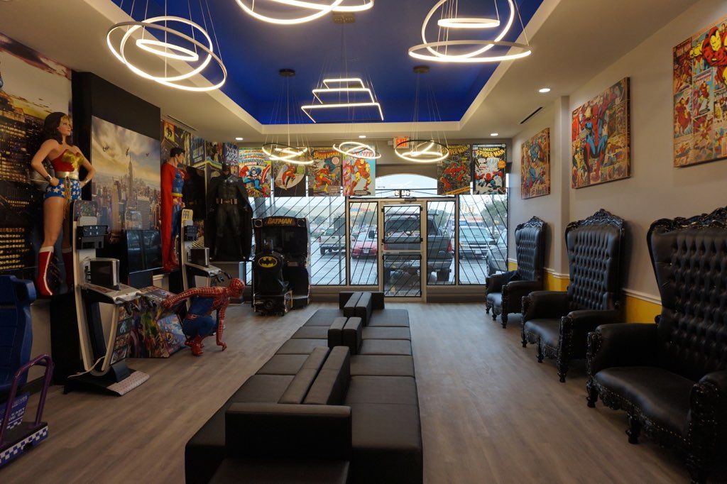 Modern salon with black seating, colorful wall art, and bright circular ceiling lights