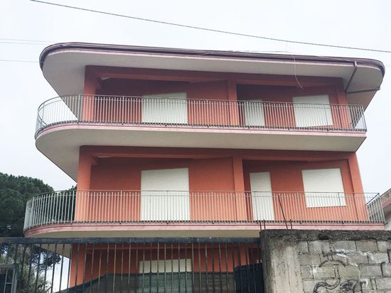 un condominio rosa a tre piani