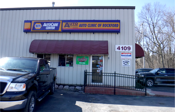 Auto Clinic and Recovery storefront with parked vehicles and address 4109 visible