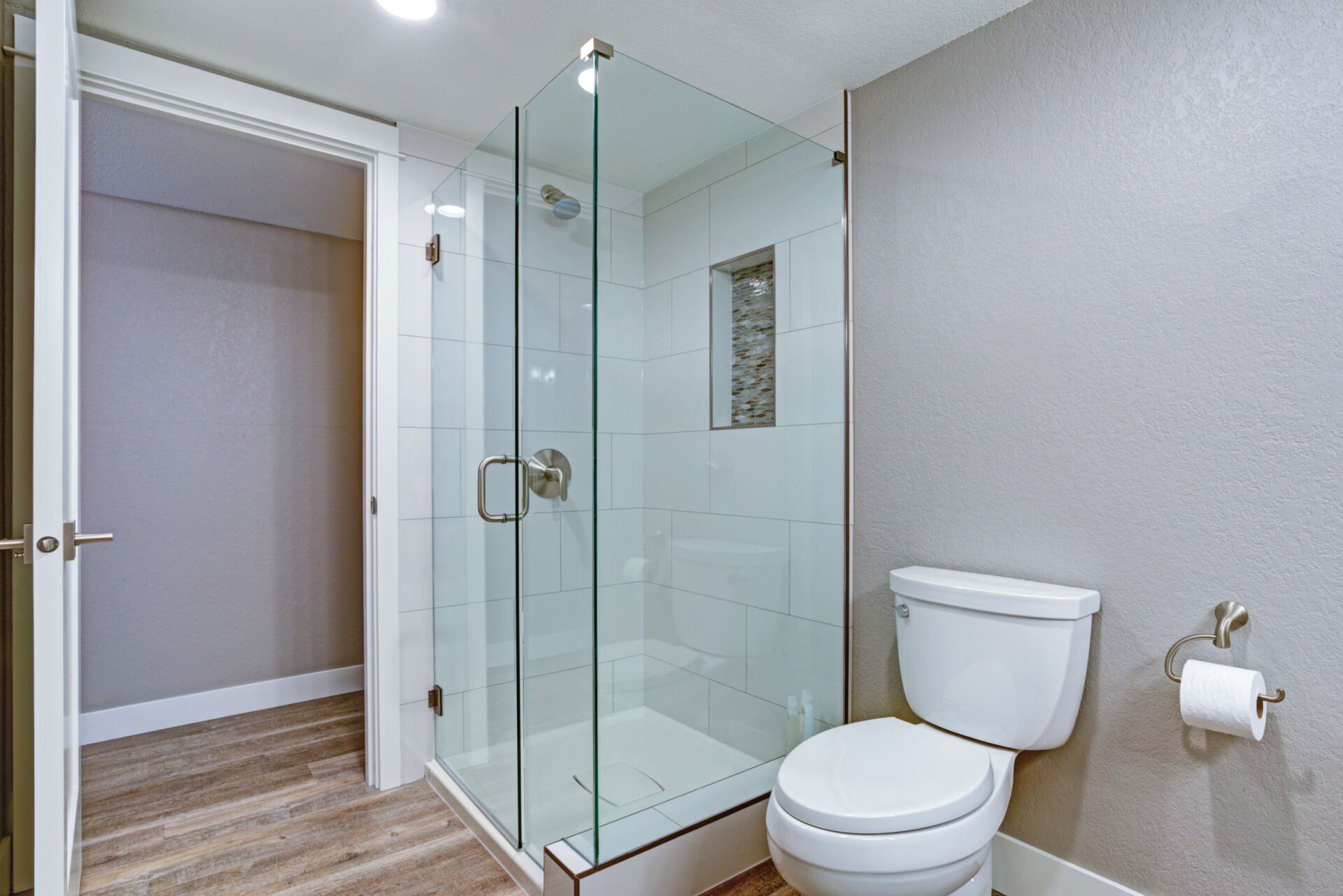 A bathroom with a toilet and a walk in shower.