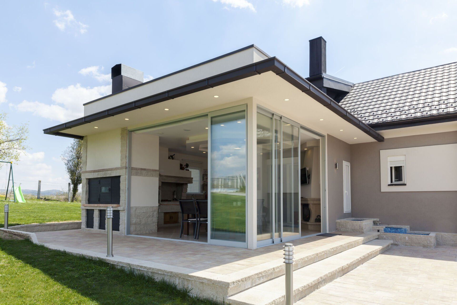 A house with a large patio and sliding glass doors.