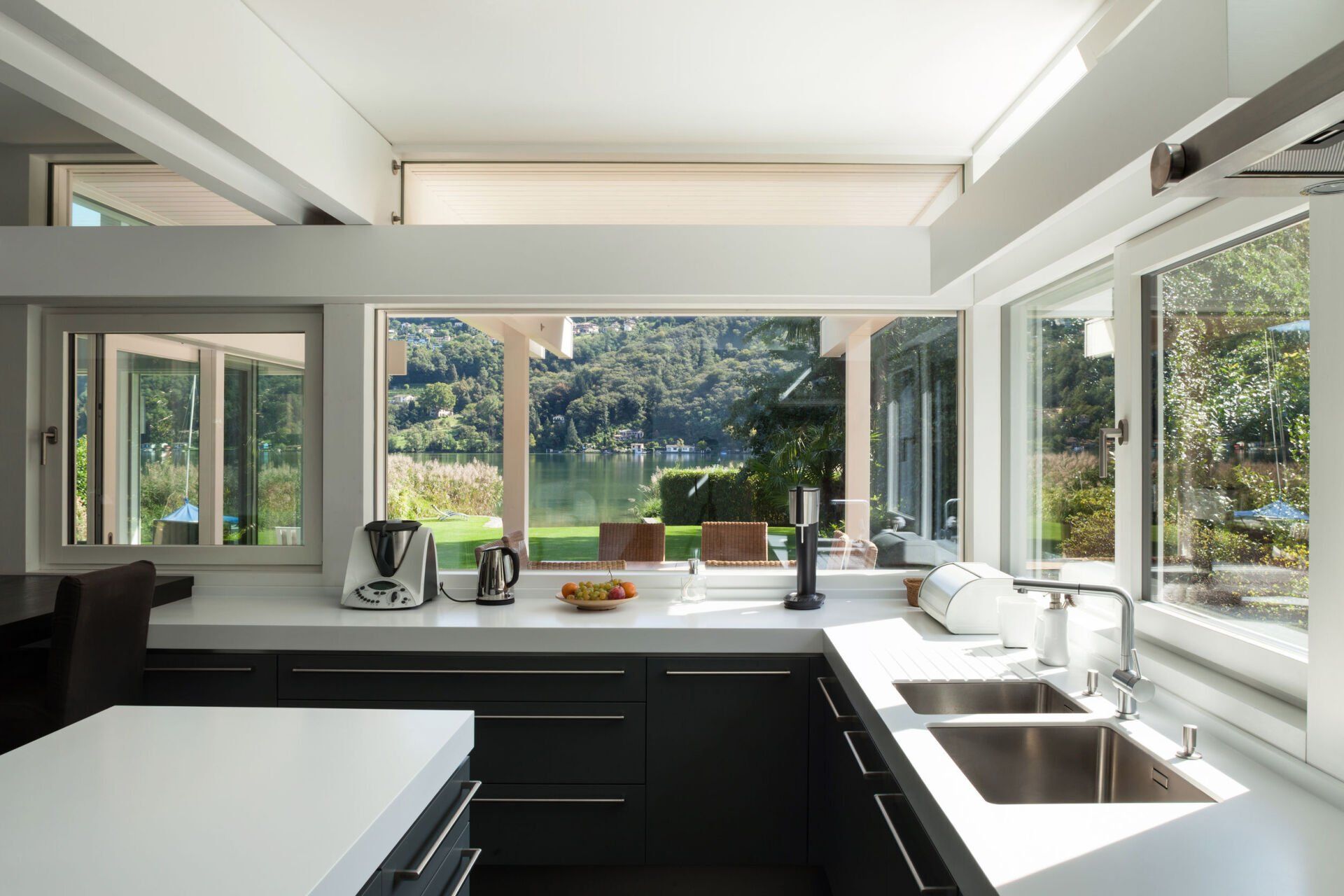 A kitchen with two sinks and a lot of windows